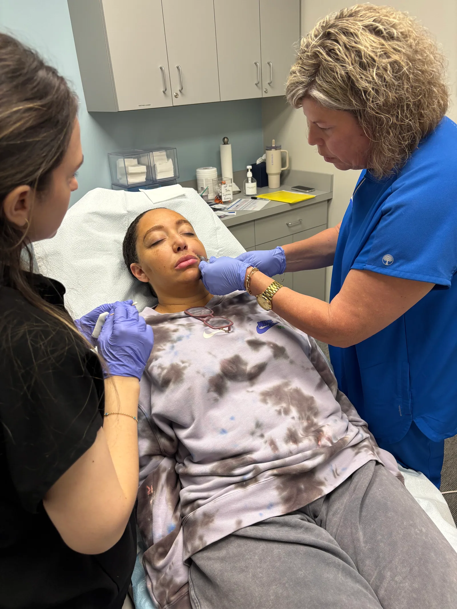 A student works with a live model while an instructor guides her
