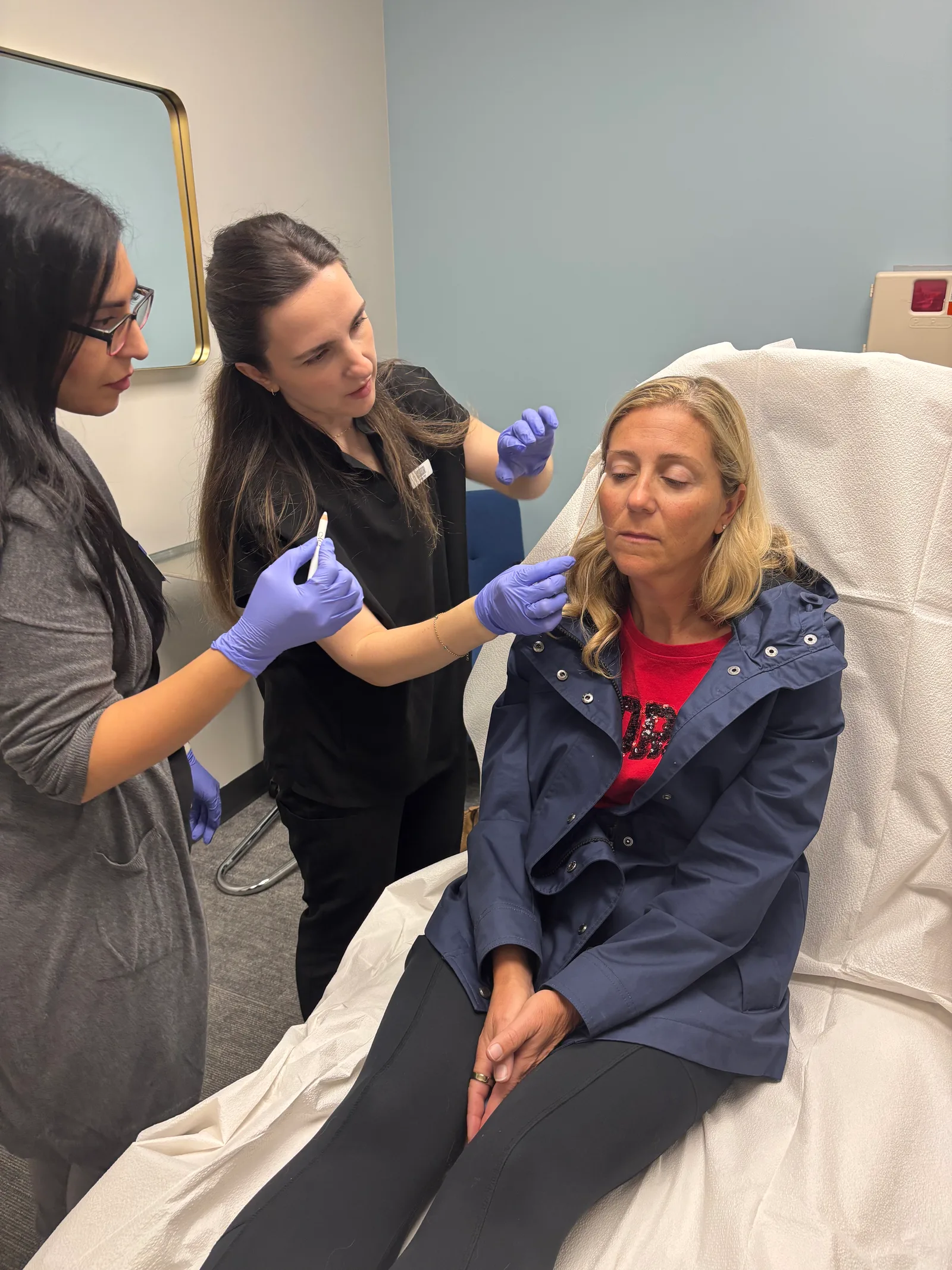 An instructor guides a student beside a treatment chair in Atlanta