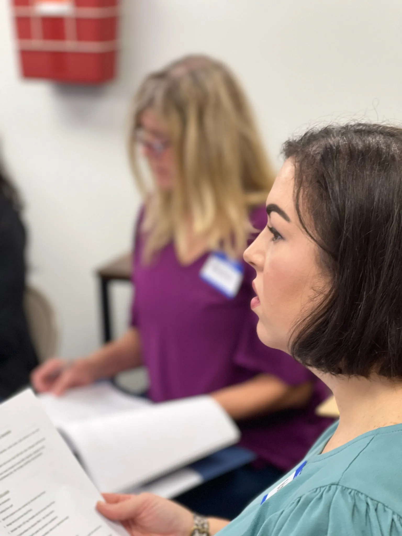 A participant listens and takes notes during class