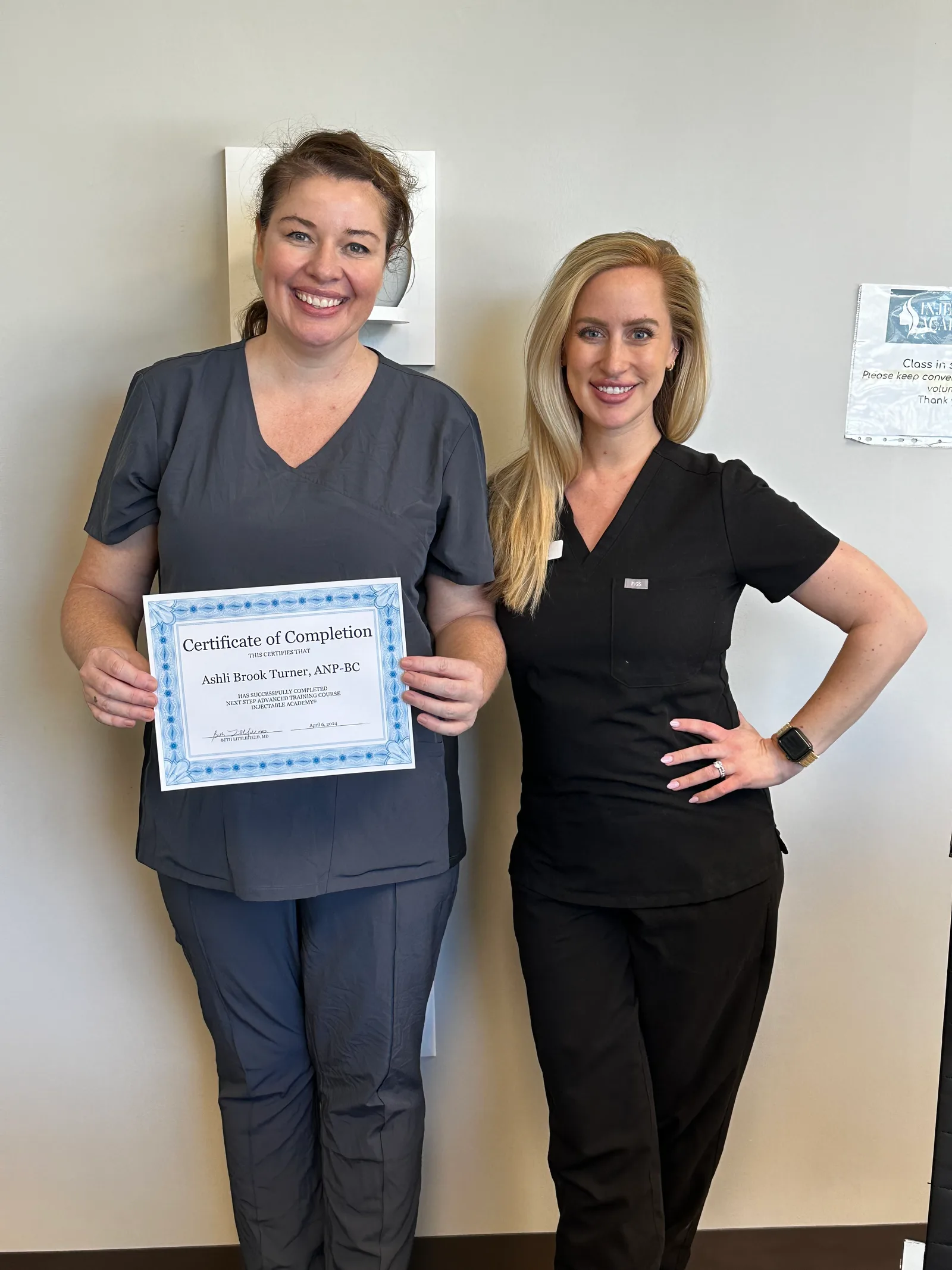 A NEXT STEP participant holds her completion certificate beside an Academy instructor