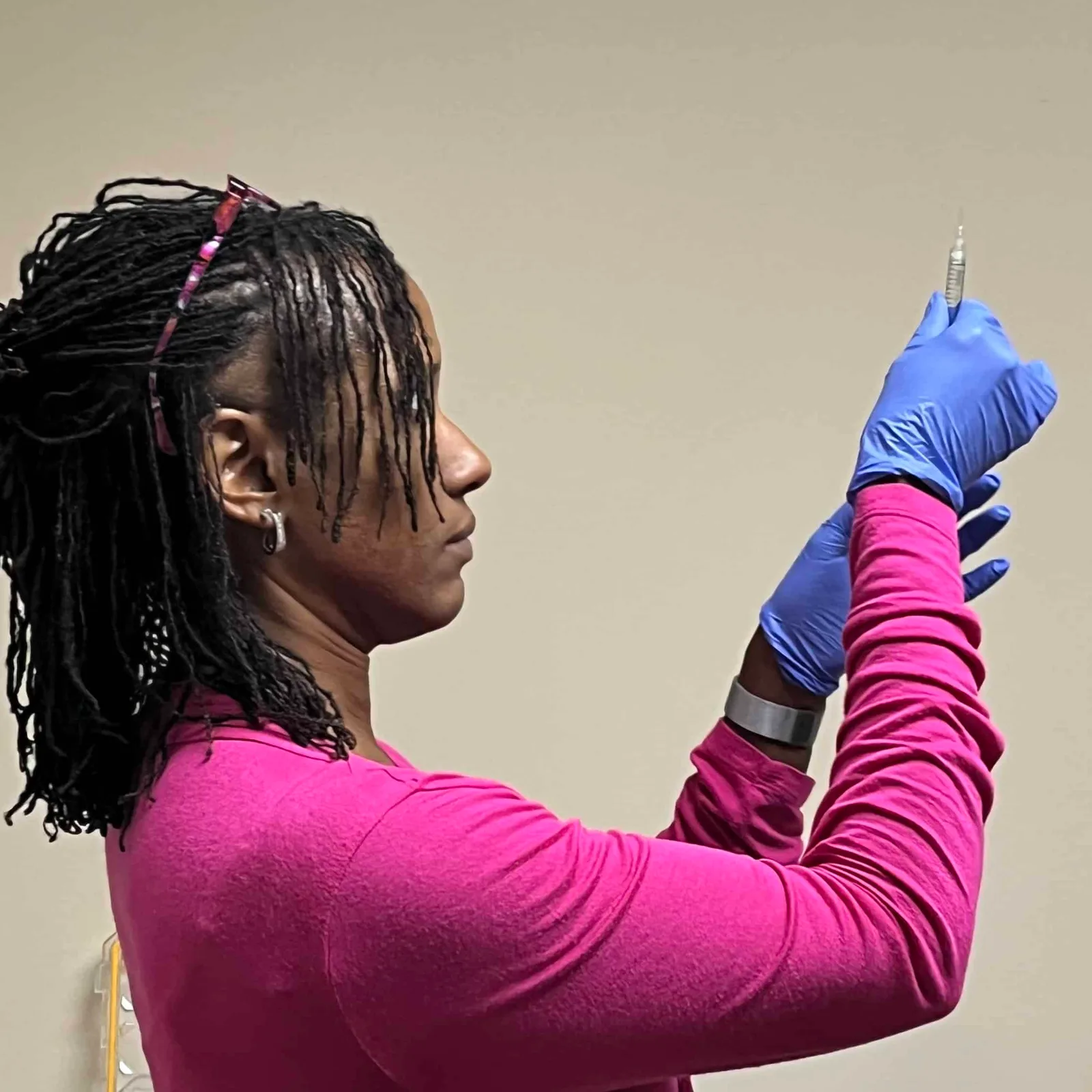 A class participant in pink prepares a syringe for hands-on practice